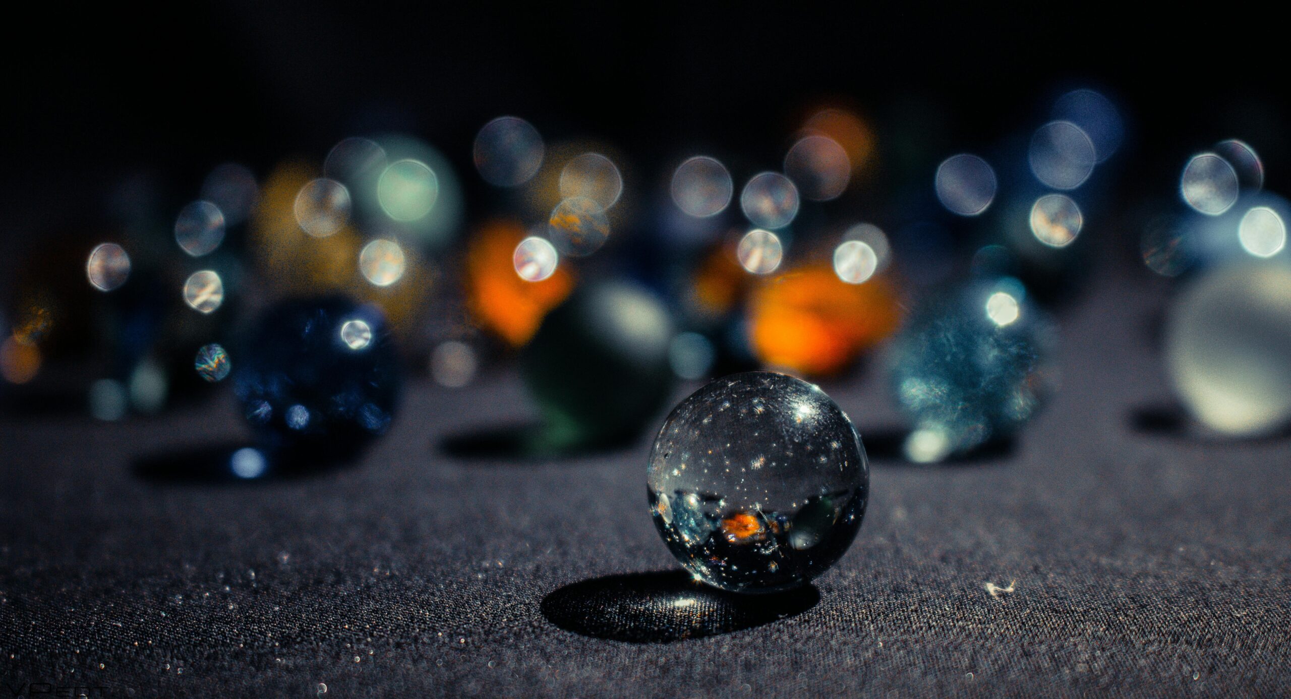 An artistic close-up of colorful marbles with a stunning bokeh effect, showcasing shimmering lights.